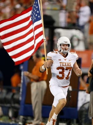 Texas Longhorns safety Nate Boyer (37) carries the american flag prior to the game during the game against the UCLA Bruins at AT&T Stadium.
