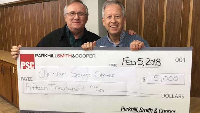Chip Whitlock, of the Parkhill Smith & Cooper architectural firm, presents a $15,000 grant to Jim Clark, director of the Christian Service Center. The funds will be used to help renovate the center’s multipurpose room kitchen.