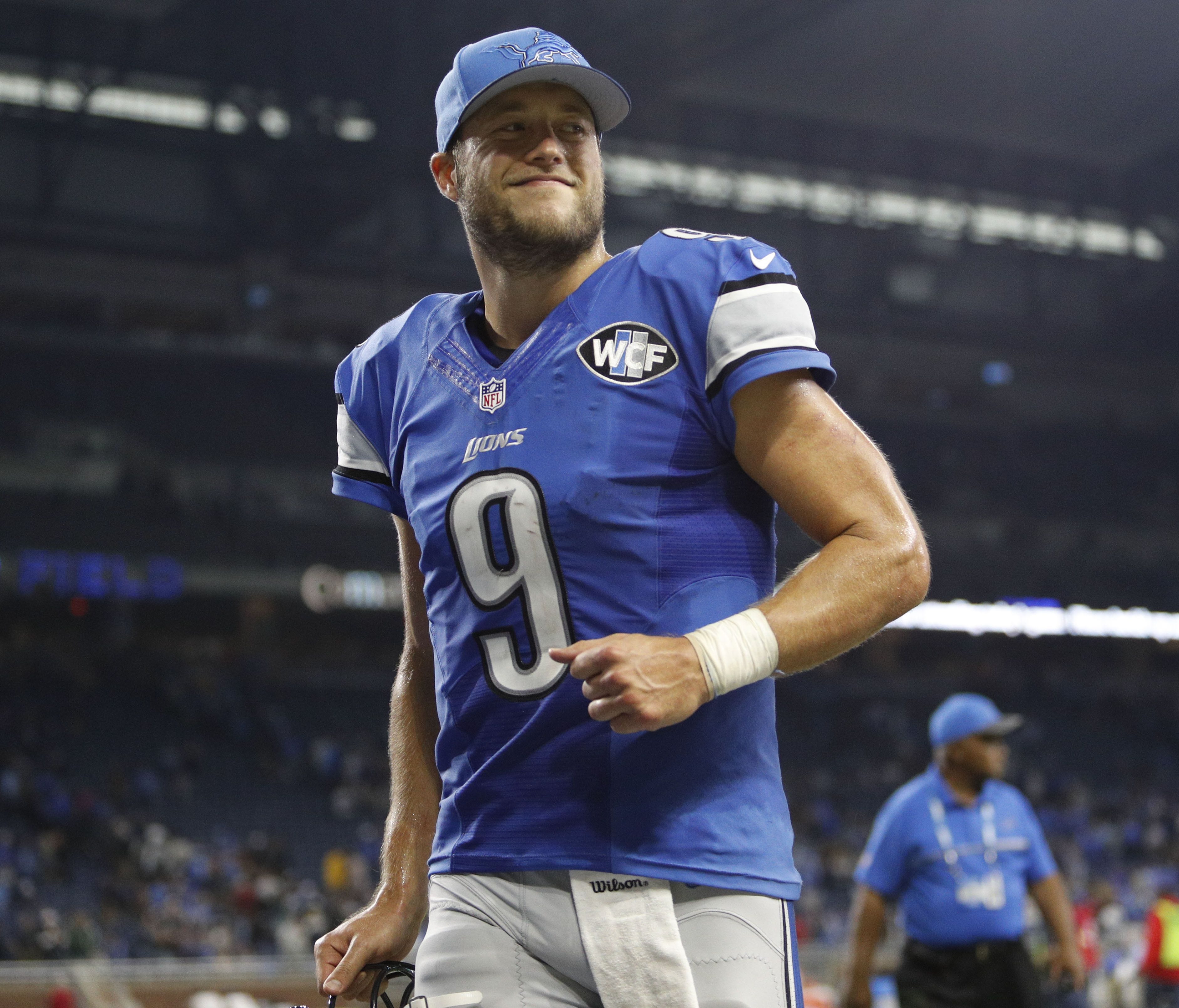 Detroit Lions quarterback Matthew Stafford (9) smiles as he jogs off the field after the game against the Los Angeles Rams at Ford Field.