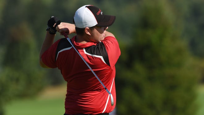 Coshocton's Logan Desender hits a tee shot at River Greens on Monday during the East District Golf Sectionals.
