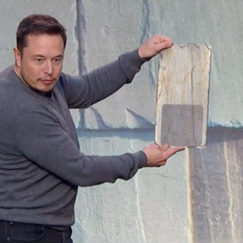 Tesla CEO Elon Musk shows a Tesla solar roof cell.