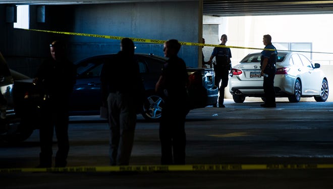 Law enforcement officers investigate the scene of a shooting death on the third floor of a parking garage on the corner of Main and Stone on Thursday, July 13, 2017. 