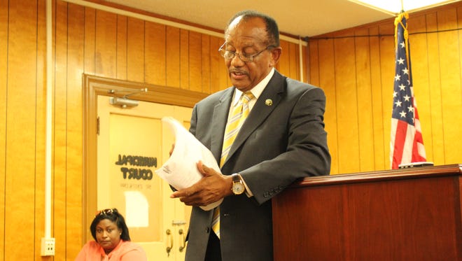 Selma Mayor George Evans examines documents Monday during a meeting with police officers who have refused to work over a pay dispute for the past week. He promised them that pay raises are near.