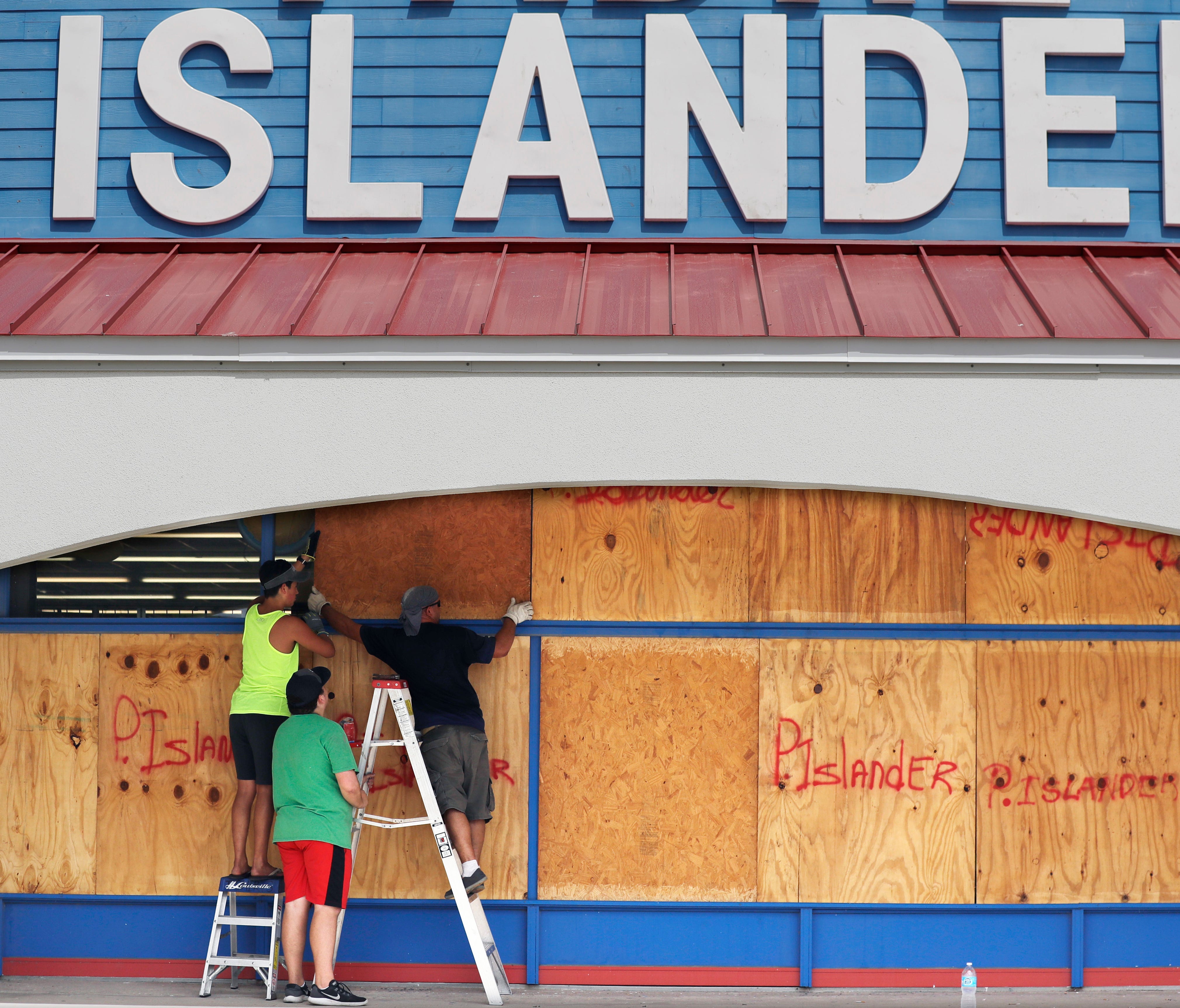 Workers cover a business with plywood in preparation for Hurricane Harvey, Thursday, Aug. 24, 2017, in Corpus Christi, Texas.