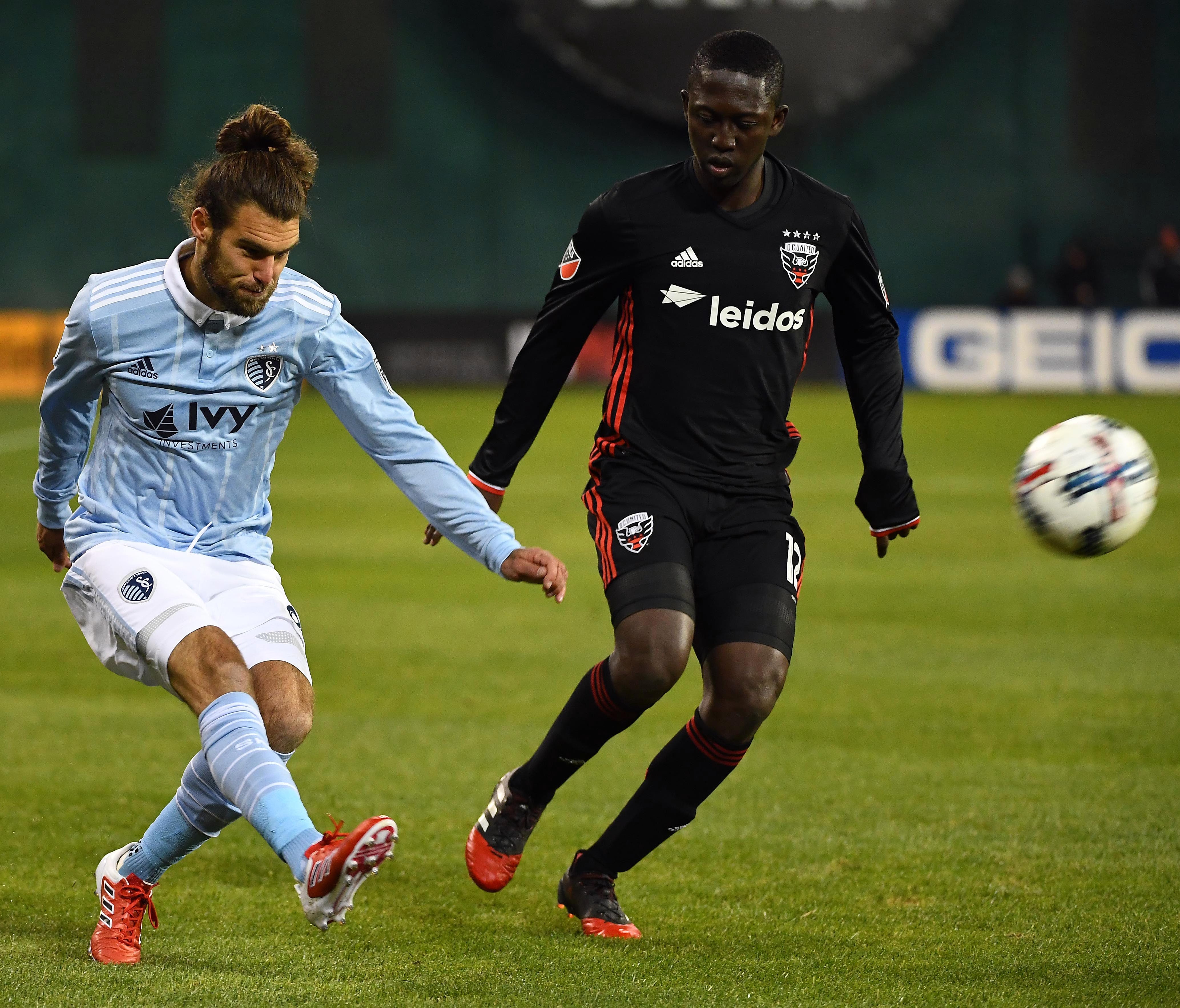 Sporting Kansas City defender Graham Zusi (8) centers the ball as D.C. United forward Patrick Nyarko (12) looks on during the first half at Robert F. Kennedy Memorial Stadium in Washington, D.C., on Mar 4, 2017.