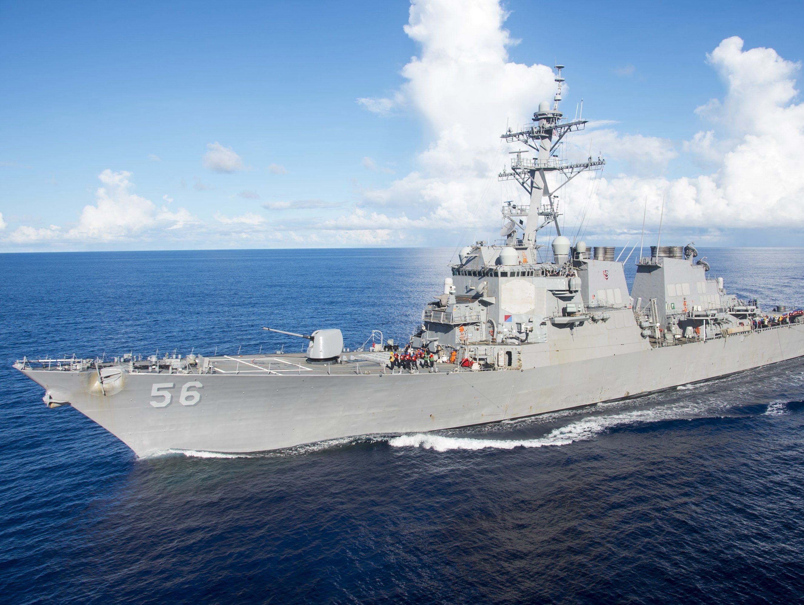 Arleigh Burke-class guided-missile destroyer USS John S. McCain (DDG 56) maneuvers alongside the amphibious assault ship USS Bonhomme Richard (LHD 6, unseen) for a refueling on the Philippine Sea on June 14, 2017.