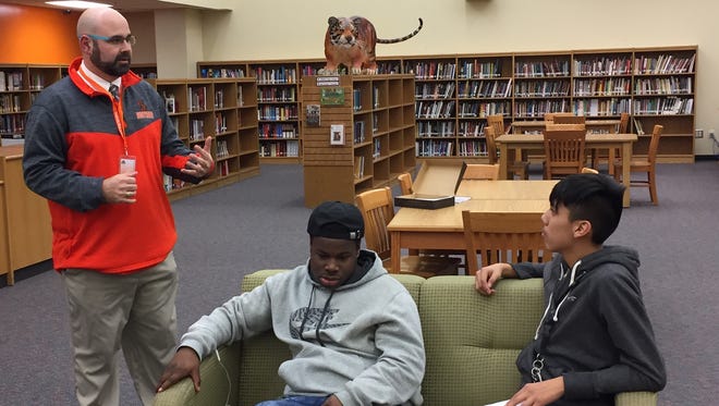 New Southside High football coach Jeremy West, left, addresses players and parents in the school's media center Monday night.