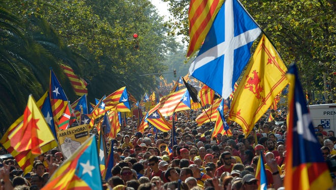 Demonstrators pushing for a secession vote for the Spanish region of Catalonia, some waving Scottish flags to support that independence vote, march in Barcelona on Sept. 11.