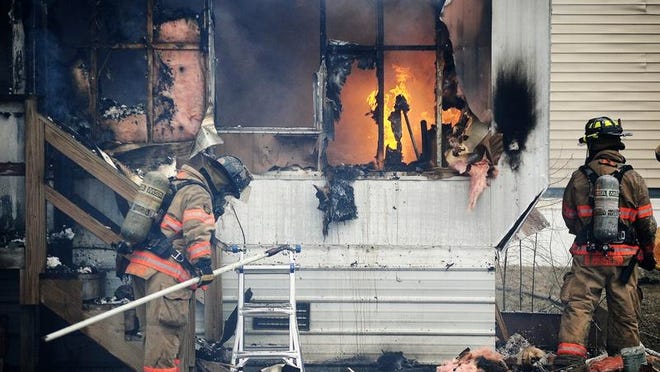 Firefighters with Sioux Falls Fire and Rescue battle a mobile home fire Monday on the 1900 block of North Tombill Place.
