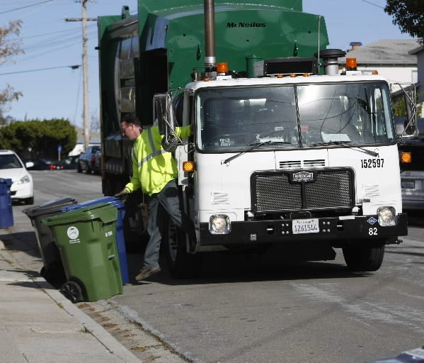 A Waste Management employee collects garbage in Castro Valley, Calif., Friday, Dec. 18, 2009.