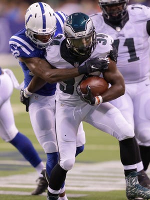 Indianapolis Colts free safety T.J. Green (32) wraps up Philadelphia Eagles running back Kenjon Barner (34) as he rushes the ball upfield during the first half of an NFL football game Saturday, Aug. 27, 2015, at Lucas Oil Stadium.