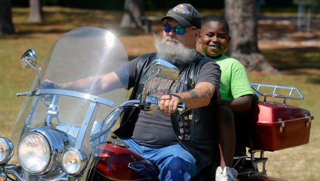 Bill Hise gives Ryan Williams,8 a free motorcycle ride Saturday, September 23, 2017 during Reimagine Montclaire, an interdenominational outreach event where churches, businesses, ministries, and community agencies come together to bless those who feel a bit hopeless. The event  included child and youth activities; food, clothing, and more giveaways; health screenings, HIV testings and community agencies distributing information about their programs.