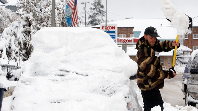 Joey Canida shovels snow away from his van on Main Street in Lead, S.D., on Oct. 15, 2013, so he can get to work.