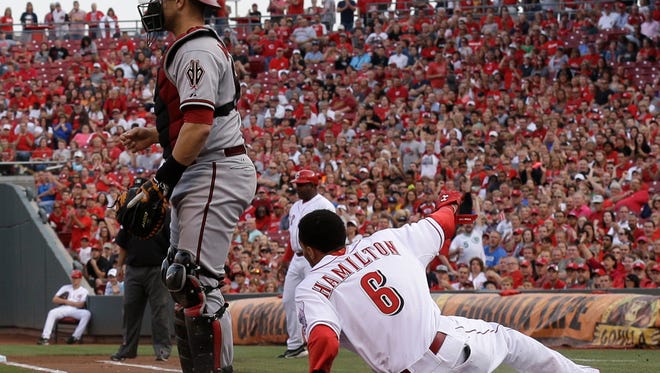 Cincinnati Reds' Billy Hamilton (6) slides safely across home plate as Arizona Diamondbacks catcher Miguel Montero waits for the throw in the first inning of a baseball game, Tuesday, July 29, 2014, in Cincinnati. Hamilton scored on a hit by Todd Frazier.