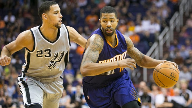 
The Suns’ Markieff Morris (right) drives to the basket as the Spurs’ Austin Daye defends during the second half of the preseason game at the US Airways Center on Oct. 16, 2014.
