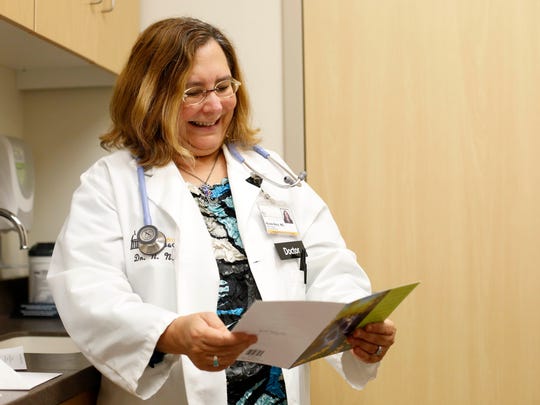 Dr. Nicole Nisly (left) smiles as she reads the card