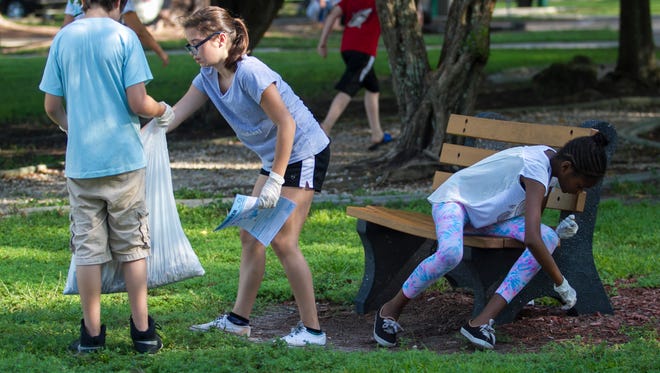 Michael Nin, left, Meredith Marshall and Somora Knight, right, pick up trash with other members of the Trafalgar Middle School Builders Club at Jaycee Park on Saturday in Cape Coral. They joined thousands of other volunteers throughout Southwest Florida to participate in the 31st Annual International Coastal Cleanup.