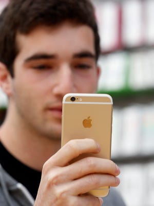 Mark Kellman uses his new iPhone 6 phone to take a photo at the Apple Store during the launch and sale of the new iPhone 6 on Friday, Sept 19, 2014, in Palo Alto, Calif. (AP Photo/Tony Avelar)