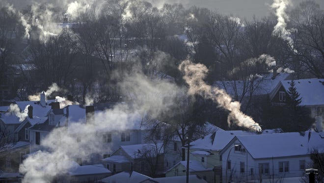 In this Wednesday Jan. 30, 2019, file photo smoke rises from the chimneys of homes in St. Paul, Minn.