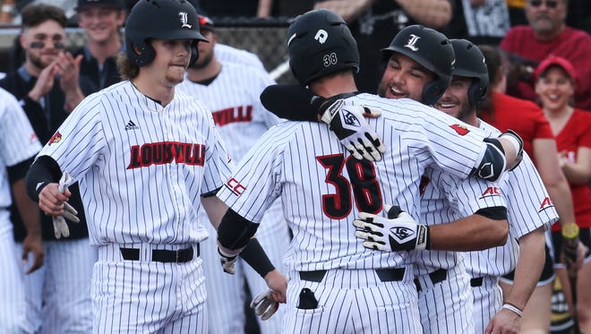 U of L’s Colby Fitch (42), right, hugs Brendan McKay (38) after McKay hit a grand slam home run against Eastern Kentucky at Jim Patterson Stadium.Feb. 22, 2017