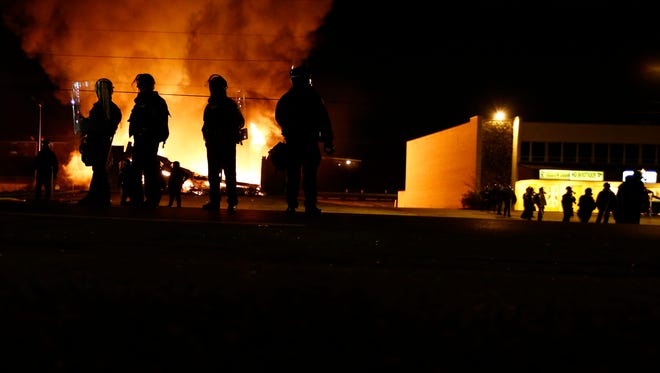 11/24/2014 -- Ferguson, MO, U.S.A  --  Protester burns several business during the riot in Ferguson after the grand jury decided not to indict Officer Darren Wilson, in the shooting of Michael Brown on Aug. 9 led to violent protests in the St. Louis suburb. --    Photo by Nick Oza, Gannett ORG XMIT:  NO 132123 FERGUSON GRAND J 11/23/2014 (Via OlyDrop)