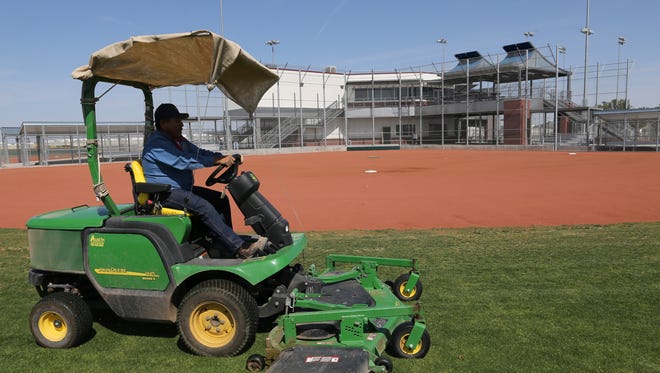 Jose Luis Martinez mows the lawn on one of the fields at the Sportspark Friday. 