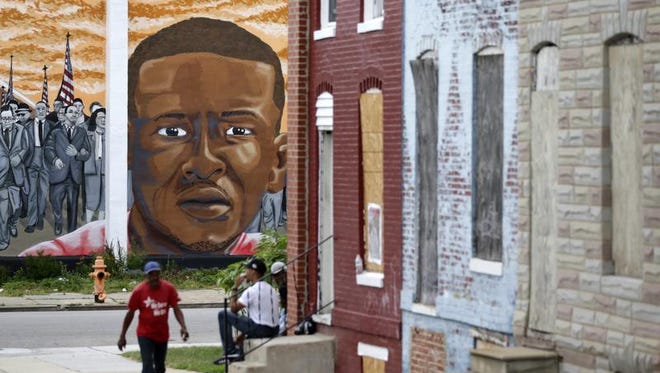 A mural depicting Freddie Gray is seen past blighted row homes in Baltimore, Thursday, June 23, 2016, at the intersection where Gray was arrested. Officer Caesar Goodson, one of six Baltimore city police officers charged in connection to the death of Gray, was acquitted of all charges in his trial Thursday. (AP Photo/Patrick Semansky)