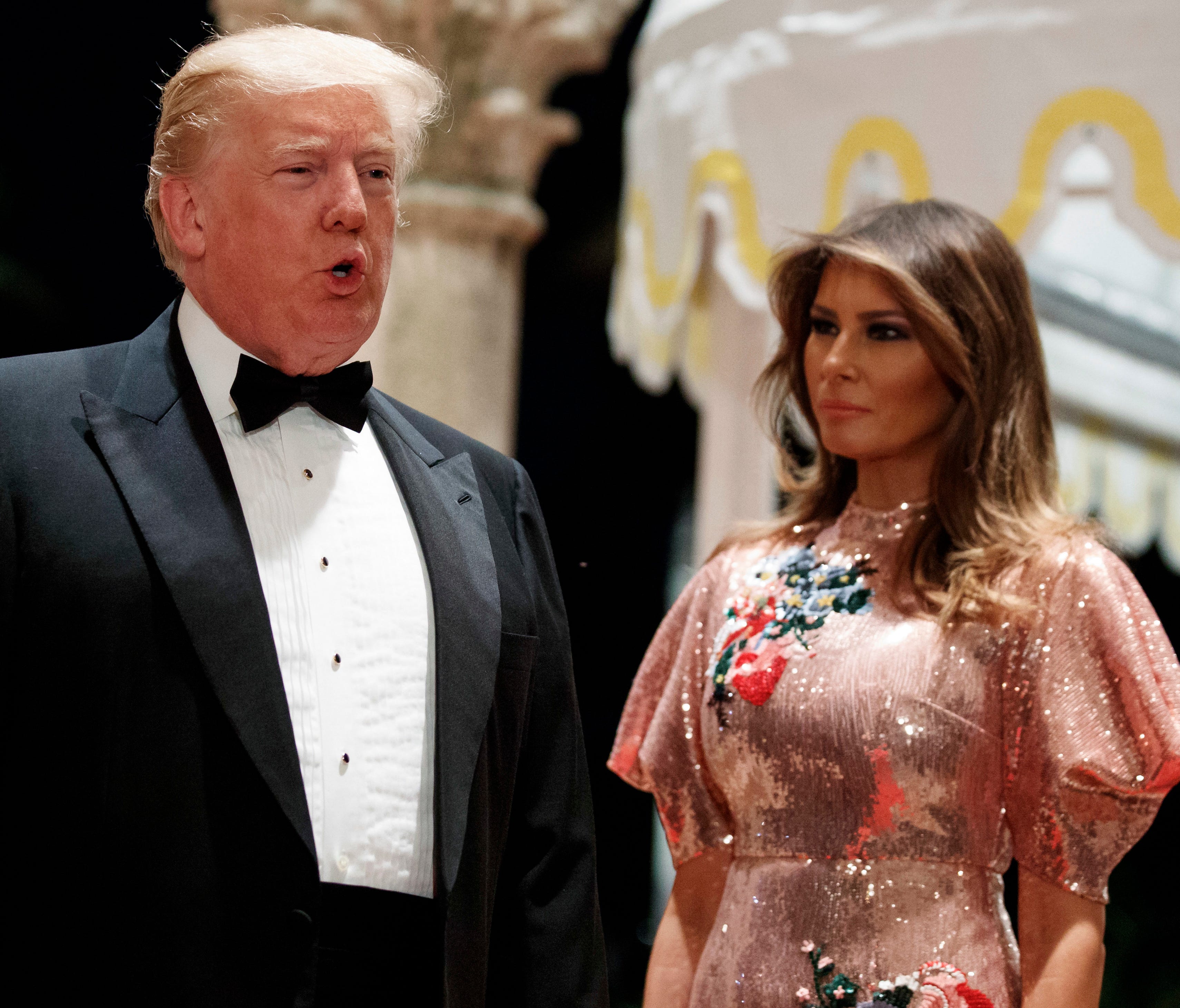First lady Melania Trump looks on as President Trump speaks with reporters at a New Year's Eve gala at his Mar-a-Lago resort Dec. 31, 2017, in Palm Beach, Fla.