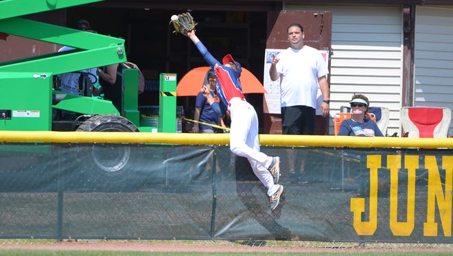 Jack Regenye of the Pennsylvania team leaps over the fence to make a remarkable catch off the bat of Chinese Taipei's Sung Yi Hsiang in the championship game of the Junior League Wold Series on Sunday at Heritage Park in Taylor, Michigan.