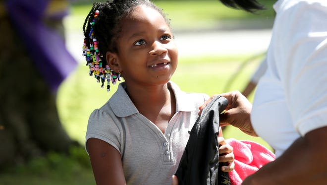 Secondgrader Leah Leslie get a new backpack Saturday at a  back-to-school celebration hosted by Fidelis Care and Divine Tabernacle of Faith.