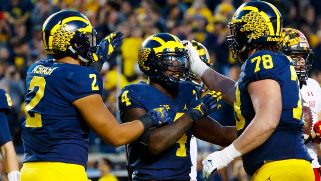 Michigan running back De'Veon Smith (4) receives congratulations from tight end Devin Asiasi (2) and offensive lineman Erik Magnuson (78) after scoring a touchdown in the second half against Maryland at Michigan Stadium.