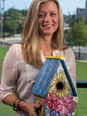 Montgomery Advertiser reporter Kym Klass holds one of the birdhouses to be auctioned off at the Sept. 29 "Making Homes Safe Havens" event, a fundraiser for the Family Sunshine Center.