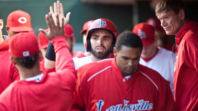 Louisville Bats' Jose Peraza, top center, is congratulated by teammates after scoring the first Louisville run in the bottom of the 4th inning on a Louisville Bats' Scott Schebler hit to right field.20 May, 2016