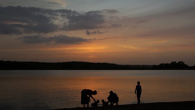 A family cools off in Shawnee Mission Lake at dusk in Lenexa, Kansas.