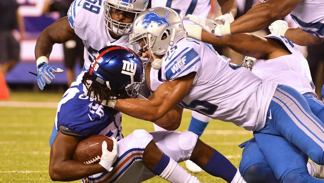 Giants running back Paul Perkins is brought down by Lions' Miles Killebrew in the fourth quarter during Monday night's game.
