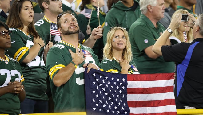 Spectators stand for the national anthem before the Green Bay Packers game against the Chicago Bears Thursday, September 28, 2017 at Lambeau Field in Green Bay, Wis.