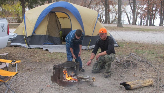 Julian Jackson and Joel Merenghi, Springfield, get a campfire going at their deer camp last weekend.