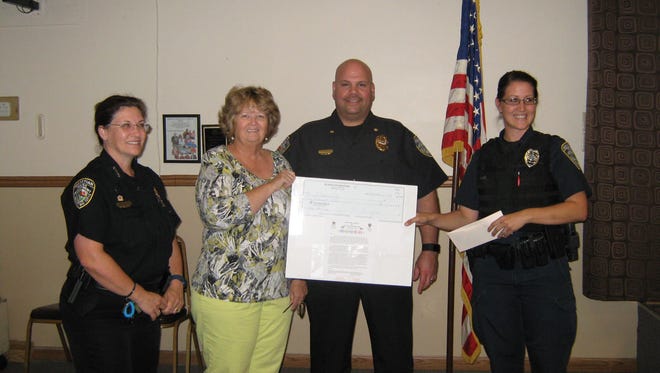 Debbie Davis (second from left), vice president of the EL-DOEs, presents Sebastian Police Chief Michelle Morris, Cmdr. Dan Acosta, and Officer Ashley Penn with a check for $1,000 for their Shop With a Cop Program.