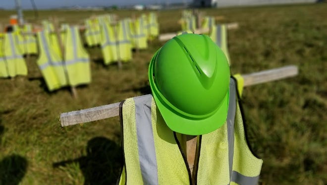 The  memorial on display near the bypass on U.S. 20 and Ohio 53 features 28 crosses draped with safety vests to honor those who died in work zone crashes in Ohio last year.