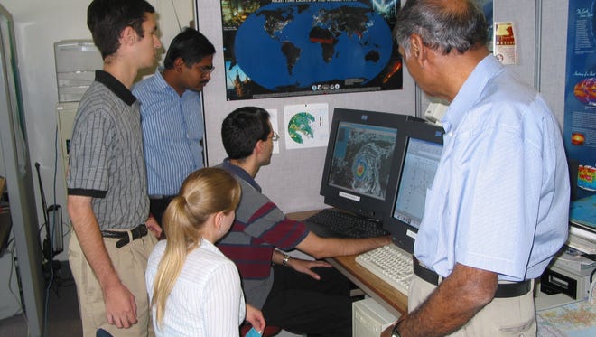 The late FSU meteorology professor T.N. Krishnamurti, far right, works with students in this 2004 file photo.