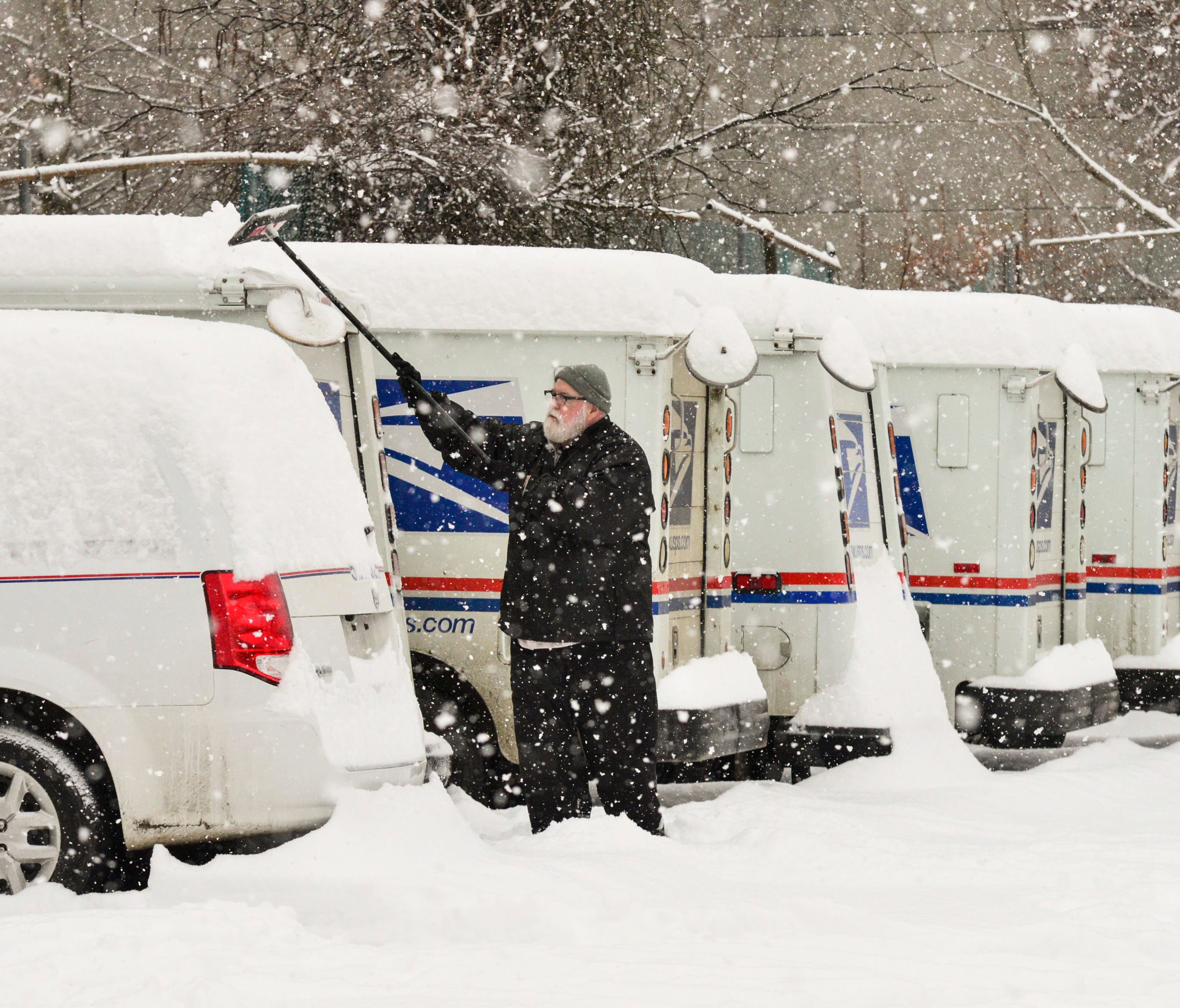 Philip Fitzwater, a city carrier assistant for the United States Postal Service, in Brattleboro, Vt., removes the snow off his vehicle before heading out on his route Monday, Dec. 12, 2016.  More snow is forecast for New England this week.