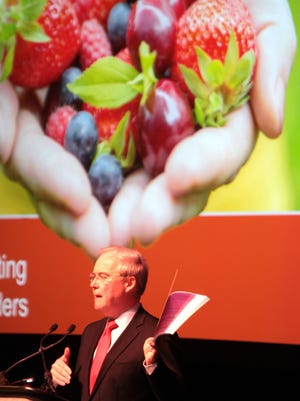Rodney McMullen, Kroger CEO, holds up a copy of the company's annual report, as he speaks at the annual shareholders meeting. The meeting was held in an auditorium at the School for Creative and Performing Arts.
