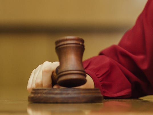 Judge in a courtroom striking the gavel and smile