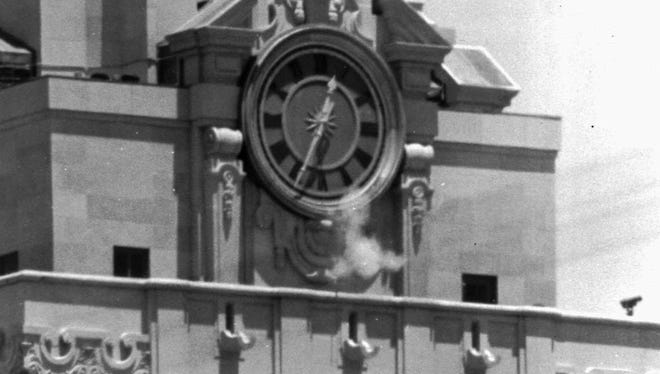 In this Aug. 1, 1966 file photo, smoke rises from the sniper's gun as he fired from the tower of the University of Texas administration building in Austin, Texas, on crowds below. Police identified the slayer of at least 16 persons as Charles J. Whitman, 24, a student at the university. Whitman's killing spree from atop the tower was so baffling to people in 1966 that then-Gov. John Connally formed a commission to study what might cause a person to erupt with such hatred and violence.