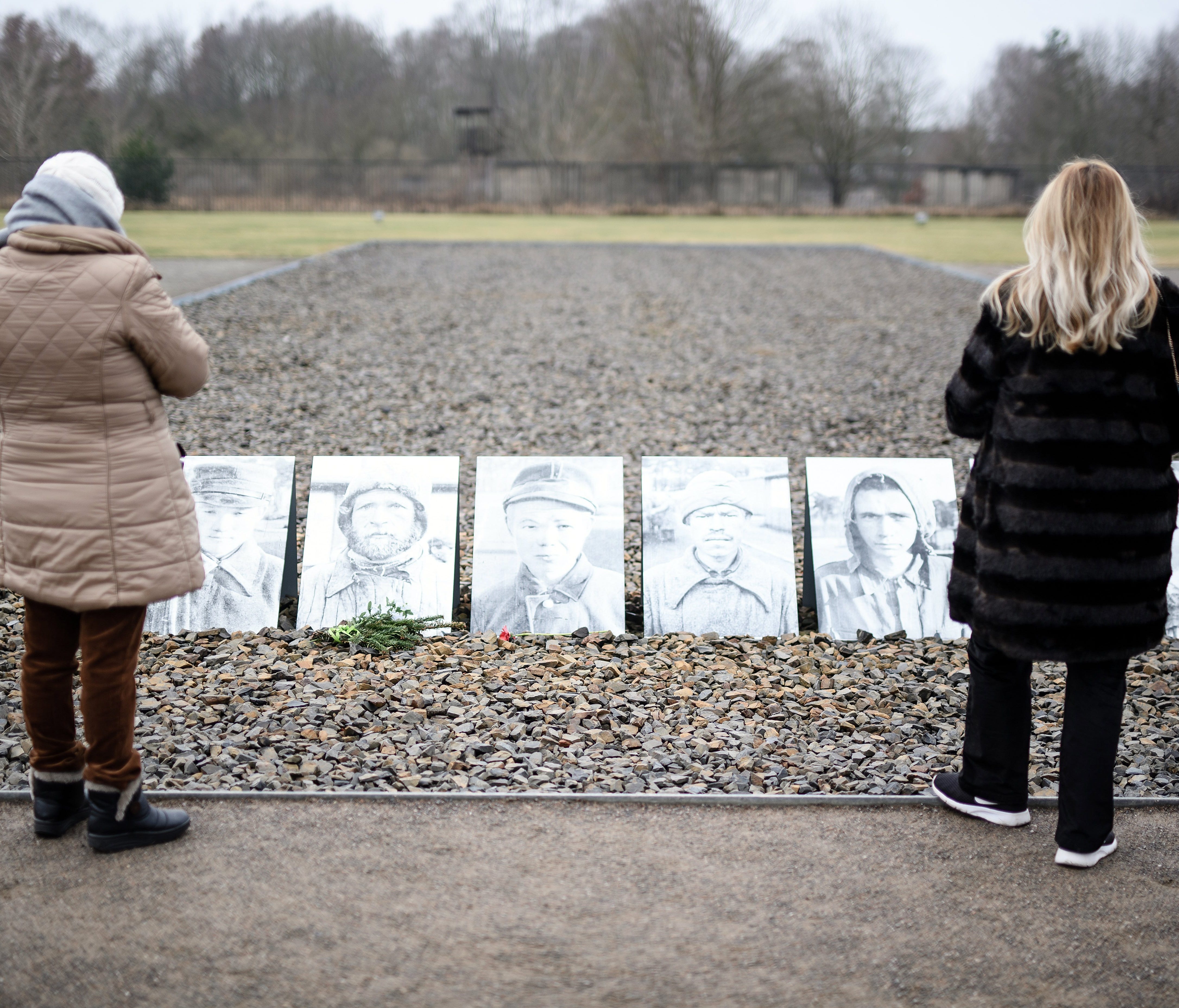 Visitors stand in front of pictures of prosecuted persons at a place, where in 1941 more than 10.000 Soviet prisoners of war were executed by being shot in the neck at the former concentration camp Sachsenhausen in Oranienburg near Berlin, on Jan. 27