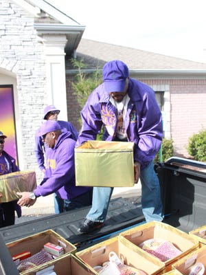 Members of the Omega Psi Phi Fraternity load boxes of Thanksgiving food into a truck to deliver to families.