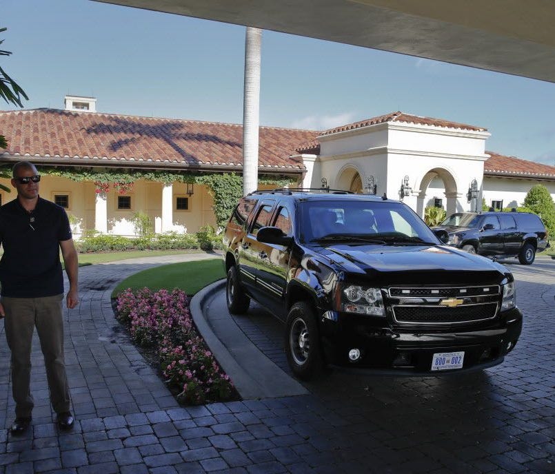 A U.S. Secret Service Agent stands near vehicles from President Trump's motorcade at the Trump National Golf Club in Jupiter, Fla., Nov. 24, 2017.