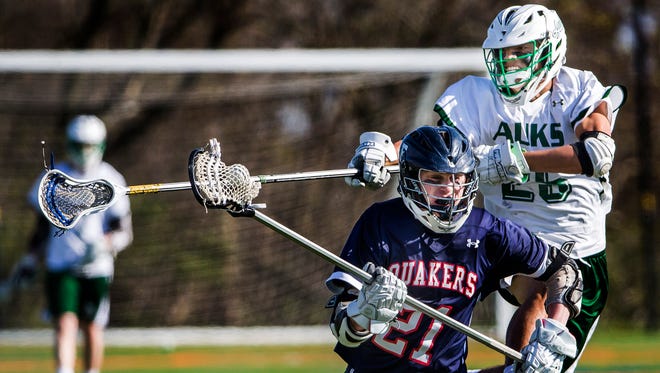 Archmere's Nicholas Salameda leaps behind Friends' Thomas Manley as he tries to knock the ball away in Archmere Academy's 13-8 win over Wilmington Friends School at Archmere on Thursday afternoon.