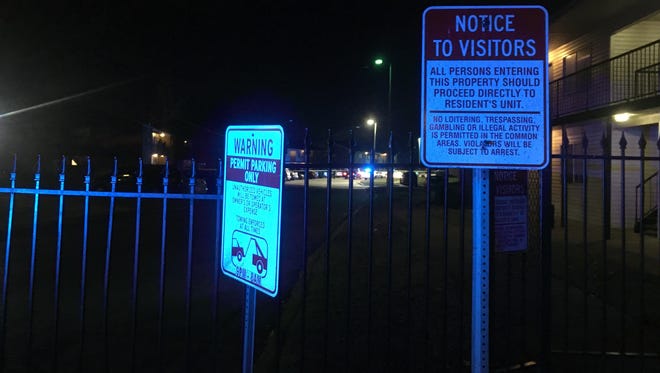 An anti-loitering sign catches the blue color from a police car's lights at the Keystone Landing apartment complex in Raleigh