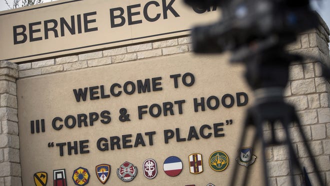 In this April 2, 2014, file photo, members of the media wait outside of the Bernie Beck Gate, an entrance to the Fort Hood military base in Fort Hood, Texas. Federal agents have seized more than 20 vehicles and the money in 10 bank accounts from a couple of U.S. Army veterans in Texas, who they say used personal information stolen from soldiers to defraud the military out of as much as $11 million. In an affidavit filed in court in June 2020 seeking to search the couple's home in Killeen, near Fort Hood, investigators described how they allegedly used a transportation reimbursement program to swindle the Army out of $2.3 million to $11.3 million.